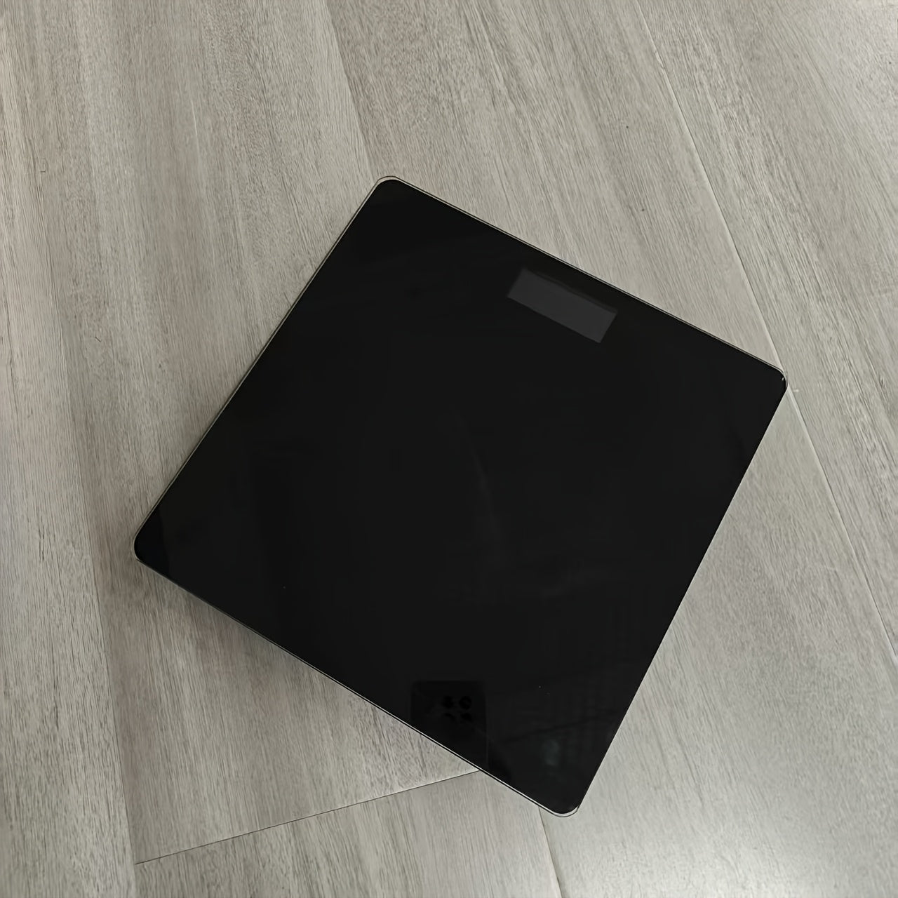 A Smart Digital Bathroom Scale, a Household Item, an Electronic Scale for Home Use, a Small Tempered Glass Scale for Domestic Use.