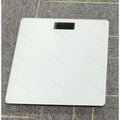 A Smart Digital Bathroom Scale, a Household Item, an Electronic Scale for Home Use, a Small Tempered Glass Scale for Domestic Use.